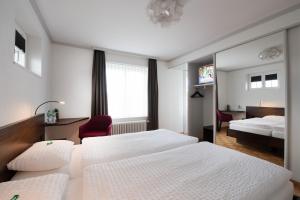 a hotel room with two beds and a mirror at Gasthaus zum Bahnhof in Berg