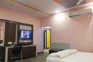 a bedroom with a bed and a tv in it at Hotel Kwality Inn in Satna