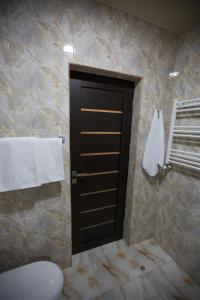 a bathroom with a black door and towels at Faria Boutique Hotel in Tsaghkadzor