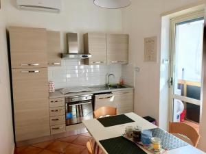 eine kleine Küche mit einem Tisch und einer Arbeitsplatte in der Unterkunft Roma Suite Cinecittà in Rom
