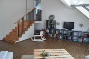 a living room with a staircase and a tv at BnB zum Schlüssel in Unterehrendingen