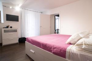 - une chambre avec un lit et une télévision murale dans l'établissement Maison di Napoli, à Naples