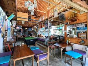a restaurant with wooden tables and chairs and a pool table at Cafe del sunshine in Ko Chang