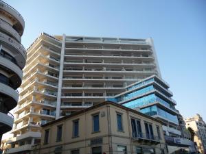a tall apartment building in front of a building at T&E Apartment in Larnaca