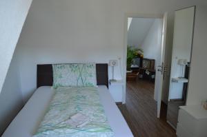 Schlafzimmer mit einem Bett mit grüner Tagesdecke in der Unterkunft BnB zum Schlüssel in Unterehrendingen