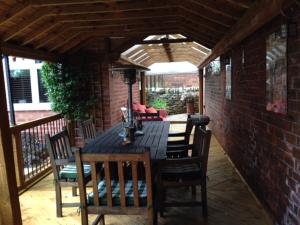 a wooden table and chairs on a patio at Somersall Park Studio in Chesterfield