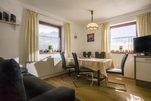 a living room with a dining room table and chairs at Bauernhof Hinterfirst in Söll