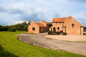 a large brick building with a winding road at Lodge Barns in Fiskerton