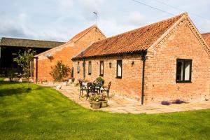 a brick building with a table and chairs in a yard at Lodge Barns in Fiskerton