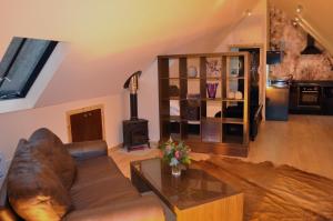 ein Wohnzimmer mit einem Ledersofa und einem Holzofen in der Unterkunft Finlaystone Barns in Port Glasgow