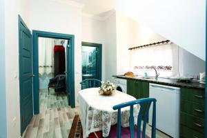 イスタンブールにあるBlue Suites by Vのキッチン(白いテーブル、青いキャビネット付)