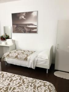 a bedroom with two beds and a picture on the wall at Vacation Venice Rooms in Mestre
