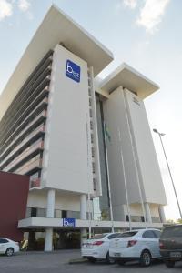 um grande edifício com carros estacionados em frente em Best Hotel Sobral em Sobral