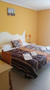 a bedroom with a large bed with two towels on it at Costa HP in Castelldefels
