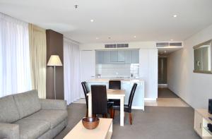 a living room with a couch and a table with chairs at APTonNorthTCE in Adelaide