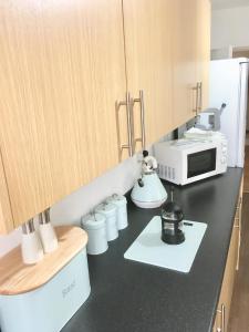 a kitchen with a black counter top with a microwave at Snowdon Cottage in Caernarfon
