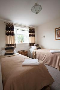 1 dormitorio con 2 camas y ventana en Barons Court Hotel en Wolverhampton