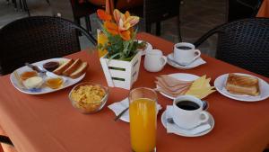 a orange table with breakfast foods and coffee on it at Ksenonas Biktoria in Loutra Amarantou
