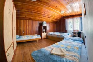 a room with two beds and a wooden ceiling at Chata Advokátka in Janske Lazne