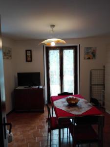 マルチェージネにあるCasa Marilenaの赤いテーブル、椅子、テレビ付きのダイニングルーム