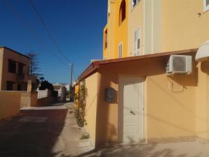 un bâtiment avec une porte blanche à côté d'une rue dans l'établissement Full comfort flat west sicily, à Marsala