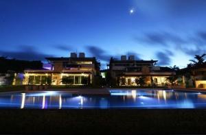 a large pool in front of some buildings at night at Pipa Residence in Pipa