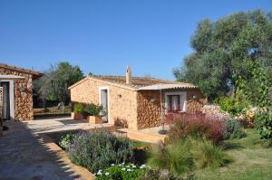 a stone house with a garden in front of it at Can Porretí Agroturisme in Lloret de Vistalegre