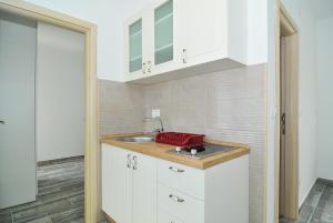 a kitchen with white cabinets and a sink at Apartments Edera in Tivat +75 photos