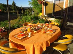 einen Tisch mit Essen auf der Terrasse in der Unterkunft L'Horizon Vert in Sembadel