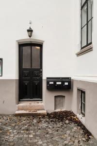 uma porta preta do lado de um edifício branco em Josefinesgate Apartments em Oslo