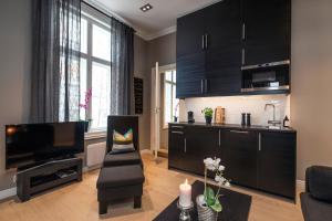 Josefinesgate Apartments في أوسلو: غرفة معيشة بها دواليب سوداء وتلفزيون