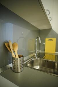 a kitchen counter with a metal container with wooden spoons at Apartment Centar in Zagreb