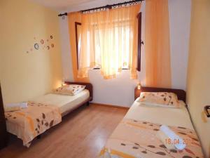 two beds in a room with a window at Holiday home Ivo in Prigradica