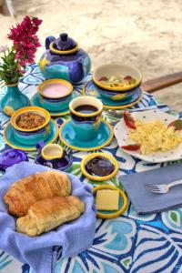 une table avec des assiettes de nourriture et des tasses de café dans l'établissement The Isabela Beach House, à Puerto Villamil