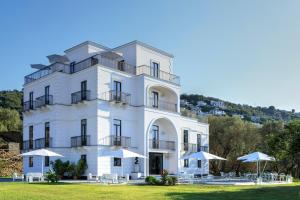 a white building with umbrellas in front of it at Anna Belle Elegant AgriResort in Sorrento