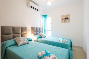 dwa łóżka w pokoju z niebieską pościelą w obiekcie Apartamento Ventura Rodriguez 39 w Maladze