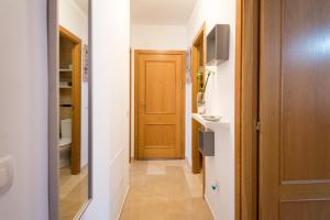 korytarz prowadzący do łazienki z drewnianymi drzwiami w obiekcie Apartamento Ventura Rodriguez 39 w Maladze