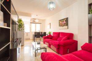 salon z czerwoną kanapą i stołem w obiekcie Apartamento Ventura Rodriguez 39 w Maladze