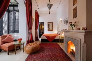 a living room with a fireplace and a bedroom at Riad Azzar in Marrakesh