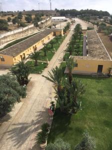 an overhead view of a courtyard with palm trees and buildings at Agriturismo La Maddalena in Acate