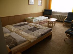 StrmilovにあるPension Pod Šibeňákemのベッドルーム1室(ベッド2台、テレビ、椅子付)