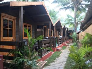 a resort with a row of houses with palm trees at Roundcube Beach Bungalows Patnem in Patnem