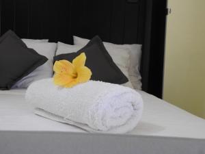 a white towel with a yellow flower on a bed at Las Flores studio 2 in Playa de las Americas