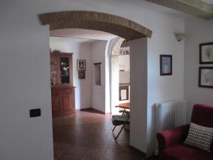 a living room with an archway and a dining room at Casa Valeria in Cinigiano