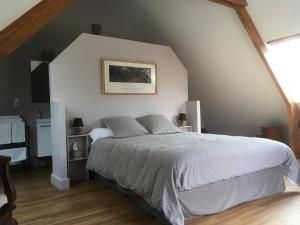 um quarto com uma cama grande num sótão em L'auberge du Mont em Le Breuil-en-Auge