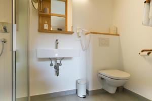 
a white toilet sitting next to a white sink at Bio Hotel Bergkristall in Schladming
