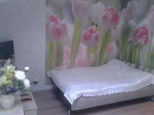 セルプホフにあるАпартаментыのピンクの花が飾られたベッドが備わる客室です。