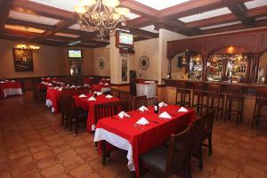 ein Restaurant mit roten Tischen und Stühlen und einer Bar in der Unterkunft Hotel Florencia in San Miguel