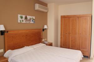 a bedroom with a bed and a dresser at Aparthotel Bahia Pinosol in Jávea