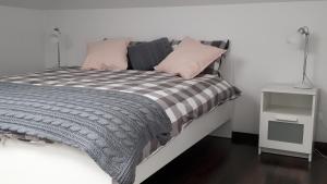 コウォブジェクにあるApartament Na Faliのピンクとグレーの毛布と枕が備わるベッド1台